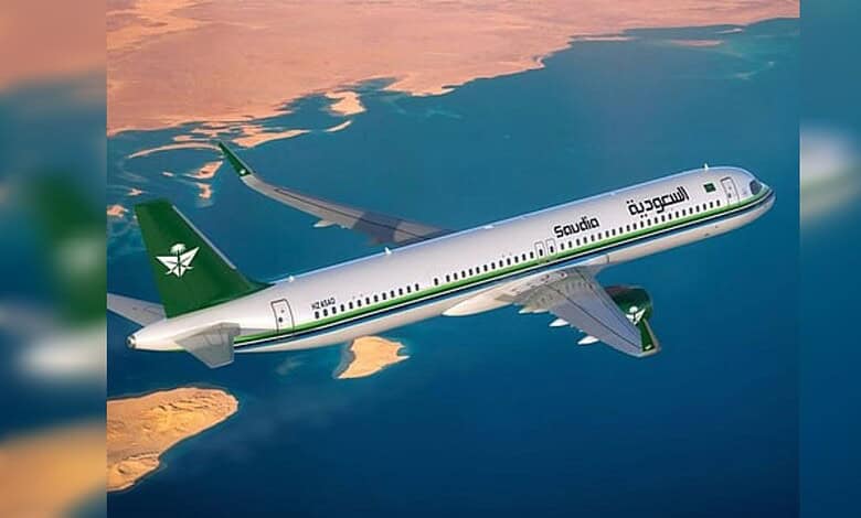 Saudia passenger aircraft flying over coastline during sunset.