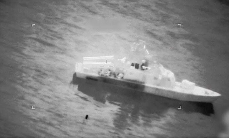 Warship navigating through ocean waters in a black and white image.