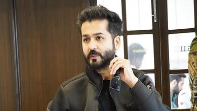 Aditya Dhar, filmmaker and writer, captured during a promotional event, showcasing his confident personal.