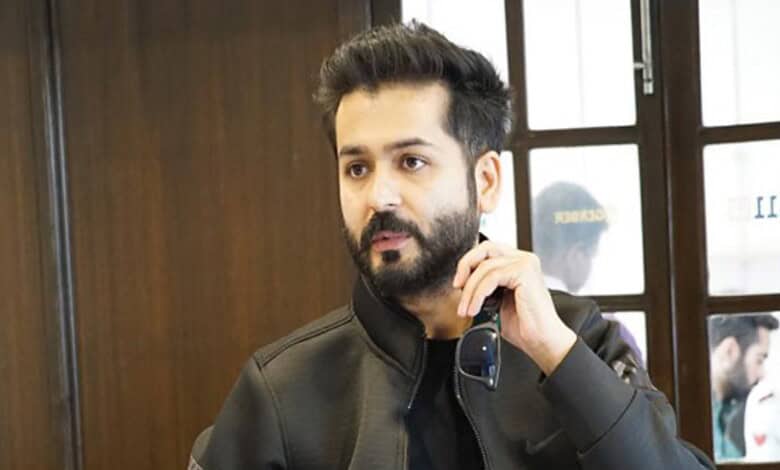 Aditya Dhar, filmmaker and writer, captured during a promotional event, showcasing his confident personal.