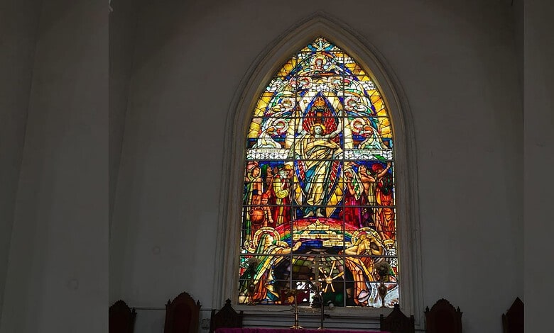 A detailed view of a stained glass window in a historic Hyderabad church highlighting its colourful craftsmanship and architectural beauty.