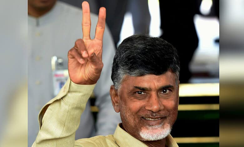 Andhra Pradesh Chief Minister holding up a peace sign at an award ceremony.