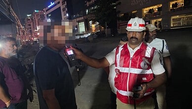 Police officer conducts sobriety check on a driver during Hyderabad's weekend drunk driving crackdown.