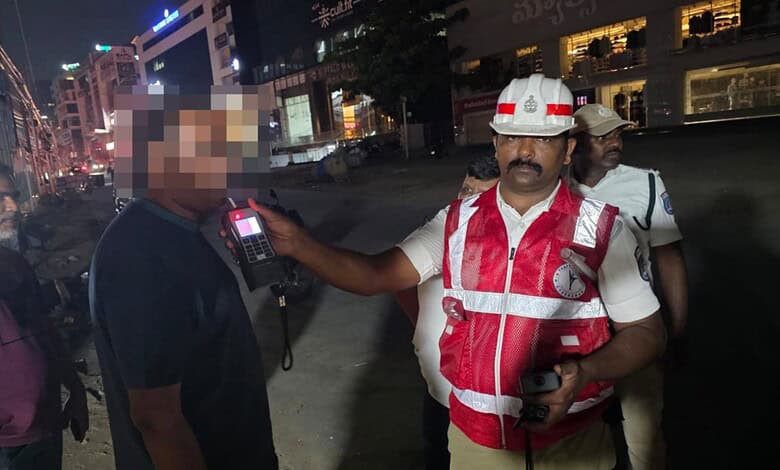 Police officer conducts sobriety check on a driver during Hyderabad's weekend drunk driving crackdown.