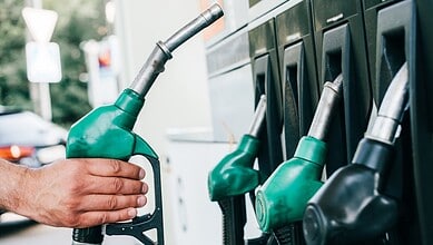 Refueling at an Indian petrol station with multiple fuel nozzles, highlighting rising fuel prices amid ec.