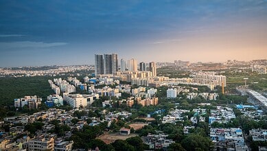 Urban skyline of Hyderabad showing residential and commercial buildings during sunset.