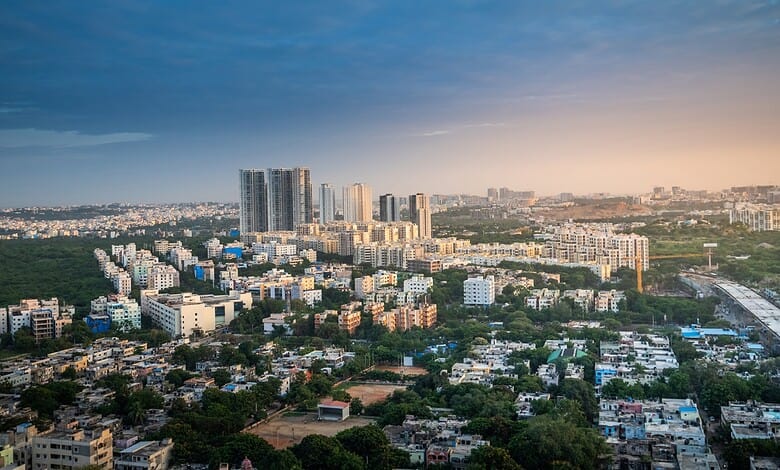 Urban skyline of Hyderabad showing residential and commercial buildings during sunset.