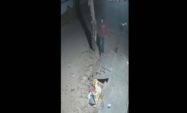 Two burglars break into a cigarette shop at night in Hyderabad, stealing stock amid a deserted street sce.