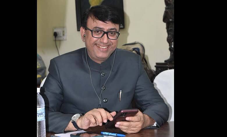 Amjad Ullah Khan smiling while using a smartphone, appointed as Telangana Quresh Conference advisor.