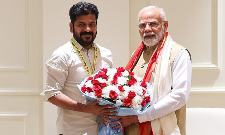 Telangana Chief Minister with Prime Minister Modi exchanging a flower bouquet during a meeting.