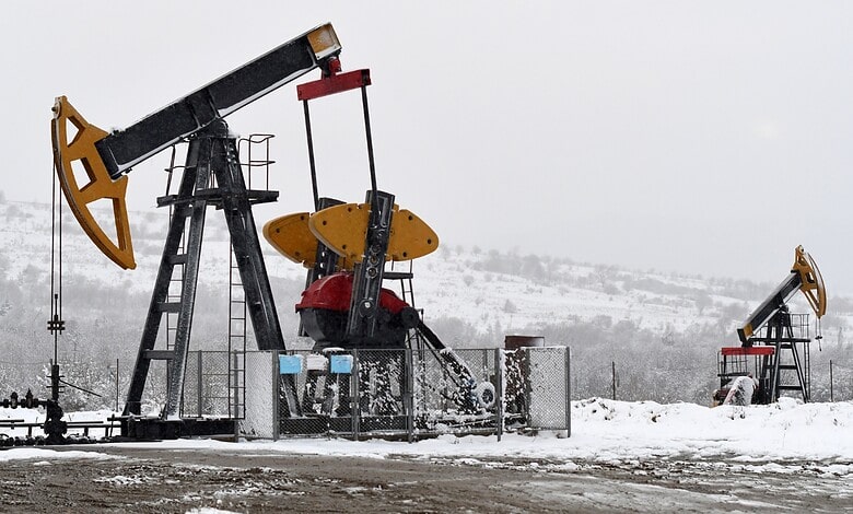 Oil pumpjacks in snowy conditions, extracting oil in cold weather.