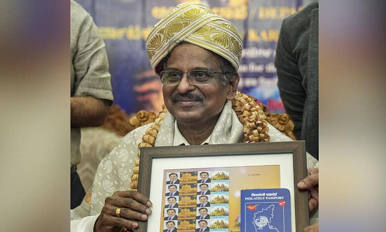 Indian scientist holding framed ISRO-related artwork at event.