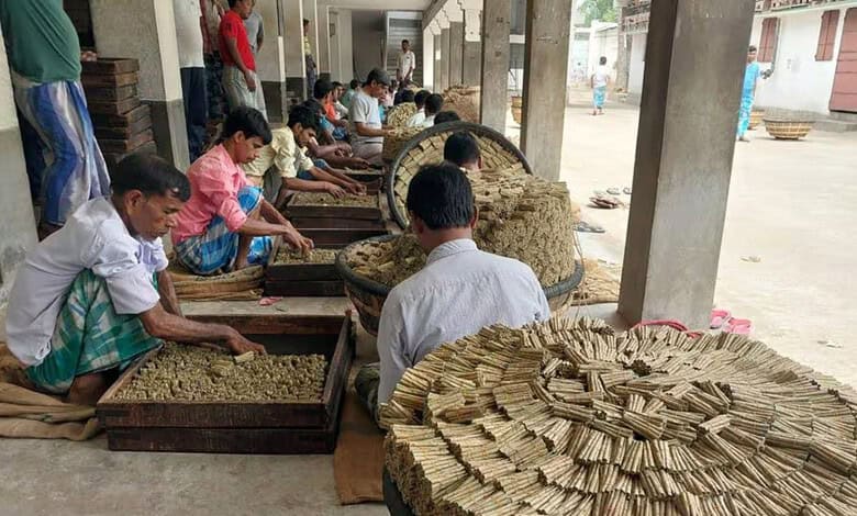 Beedi workers in Murshidabad sorting and rolling beedis under a covered area.