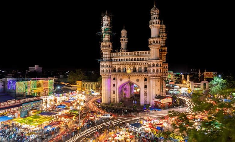 Adivasis experiencing city life in Hyderabad during the tour initiative, with the Charminar illuminated a.