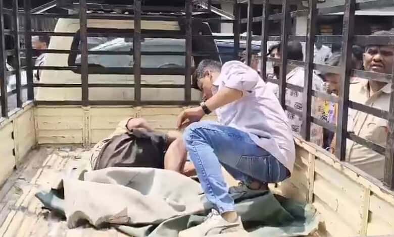 Man lying unconscious at ATM in Hyderabad, surrounded by onlookers, after being found dead.