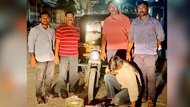 Motorcycle repair team fixing a bike at night, showcasing skilled mechanics and urban environment in Indi.