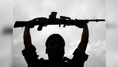 Silhouette of a person holding a rifle against cloudy sky, symbolising violence in Jharkhand.