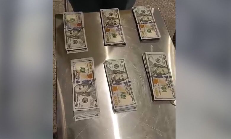 Seized US dollar bundles displayed on a table at Hyderabad Airport security.