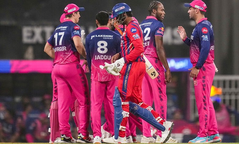 Players from Lucknow Super Giants in pink and blue uniforms on cricket field.