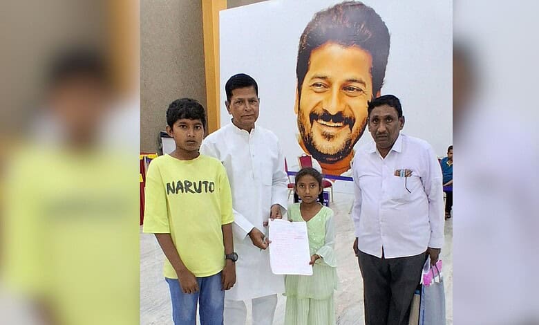 This image shows a family in Hyderabad holding a birth certificate, with a large portrait in the background.