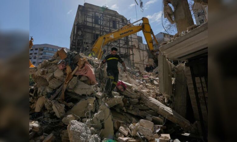 Lebanese civil defence worker walks over rubble after Israeli airstrike in Beirut.