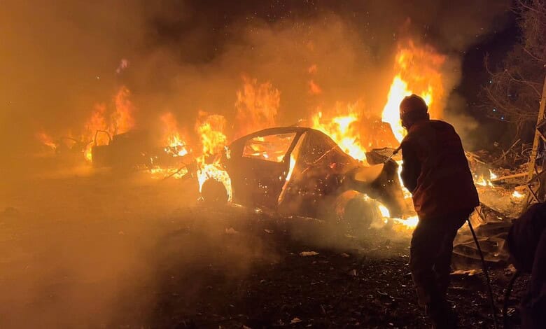 Firefighter extinguishes burning cars after airstrikes in Beirut.