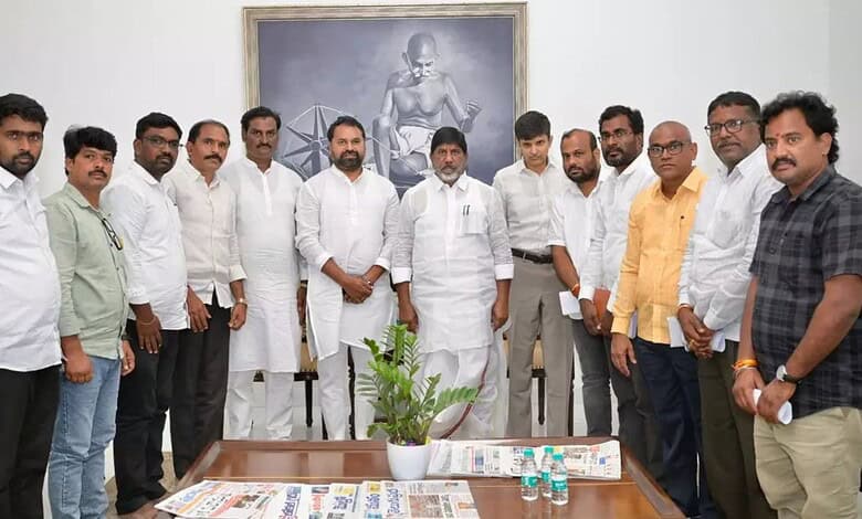 Group of men in white and casual shirts standing together in a meeting room with a framed picture on the.