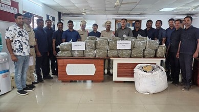 Police officials and officers display confiscated drugs on a table during a press conference.