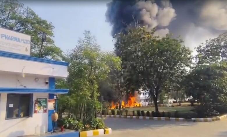 Fire at industrial site with thick black smoke and flames, emergency response required.