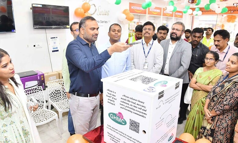 Man demonstrating e-waste recycling to community members at GHMC event.