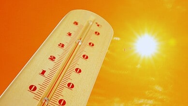 Thermometer showing high temperatures under a bright sun, highlighting heat risks in Telangana.