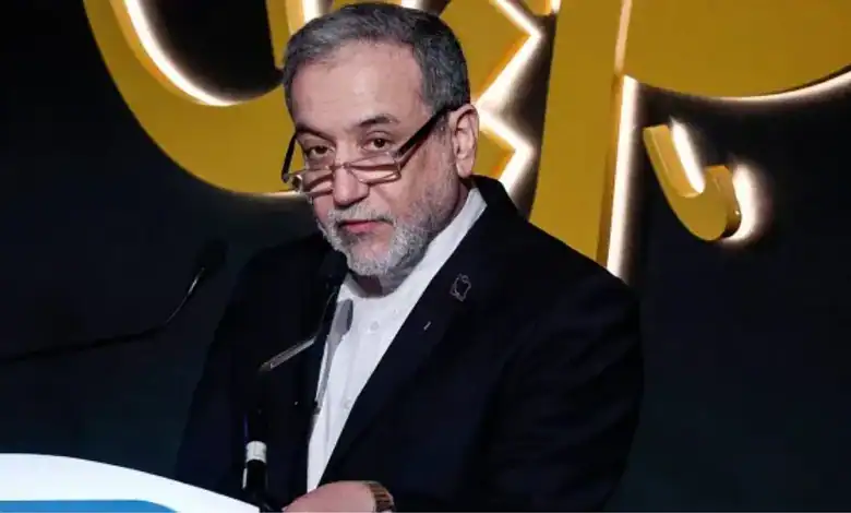 Iran Foreign Minister Abbas Araghchi speaks at a podium during an event.