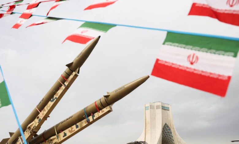 Iranian missiles on display with national flags in the background.