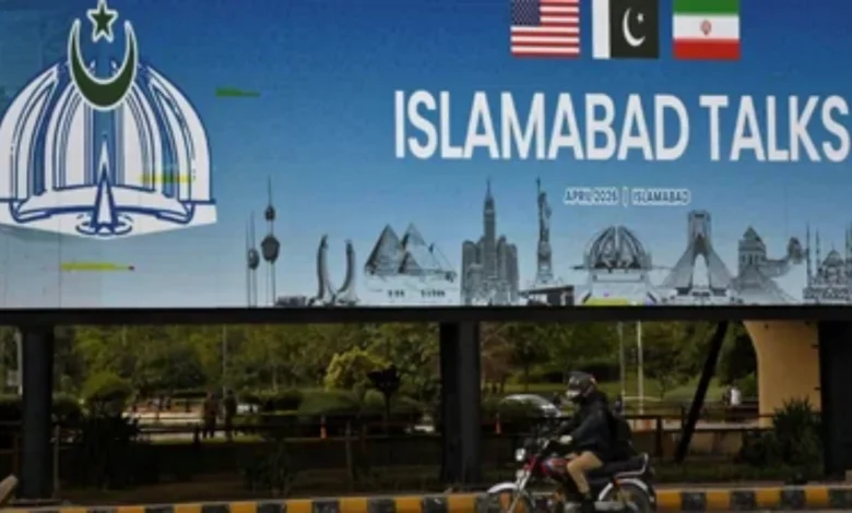 Man on motorbike passes billboard for US-Iran peace talks in Islamabad