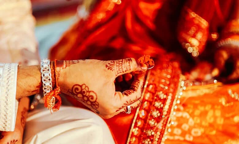 Close-up of a bride's hand with henna and jewelry during a traditional wedding in Telangana.