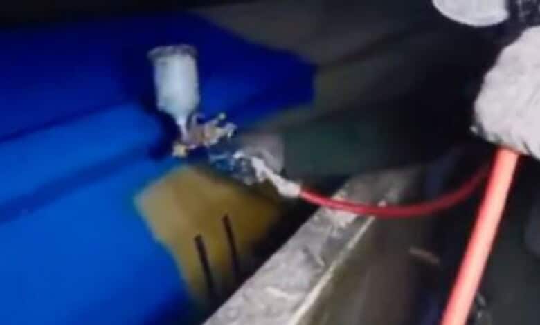 A person uses spray equipment to paint a missile blue in footage shared online.