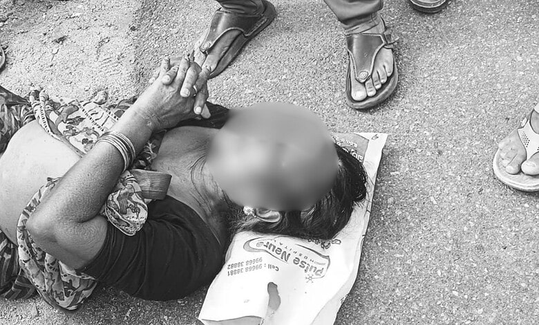 Woman lying on the ground after theft of mangalsutra in Telangana, surrounded by onlookers, during a thef.