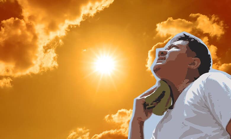 Person relaxing outdoors during sunset with a vibrant sky and clouds in the background.