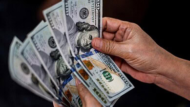 Hand holding US dollar bills, symbolising financial aid from Saudi Arabia to Pakistan.