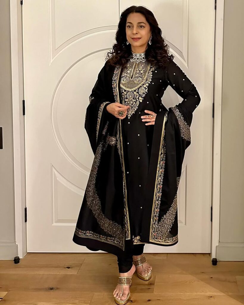 Elegant traditional black embroidered dress with silver accents, worn by a woman standing indoors, showca.