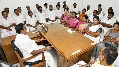 Group of political leaders and observers in a meeting room discussing government formation.