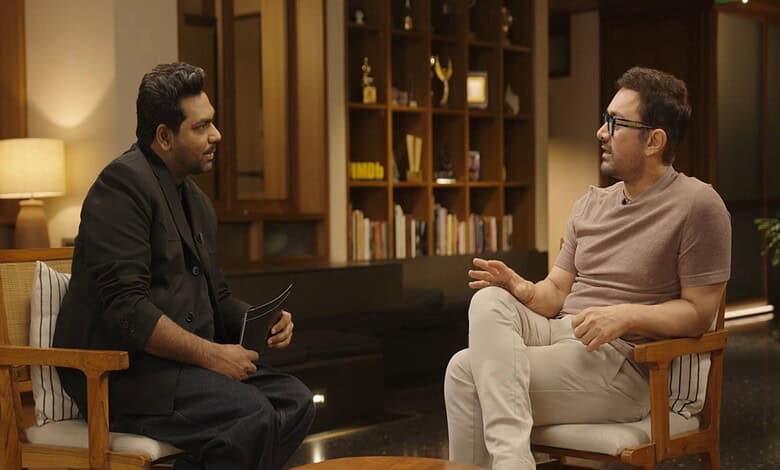 Aamir Khan speaking passionately during an interview about Hindu Goddesses in a modern indoor setting.