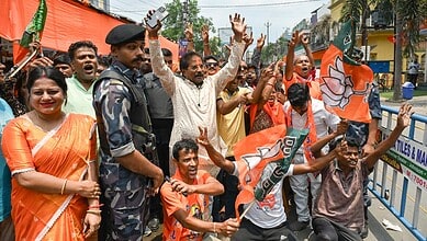 Joyful BJP supporters celebrating election results during a rally in Bengal and Assam, holding party flag.