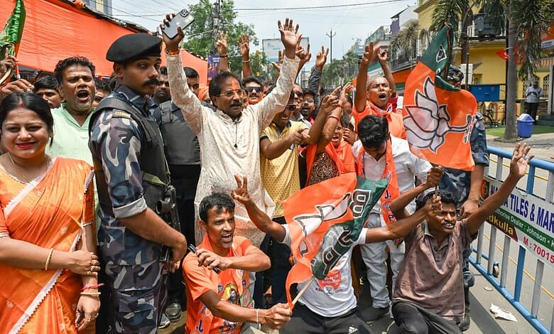 Joyful BJP supporters celebrating election results during a rally in Bengal and Assam, holding party flag.