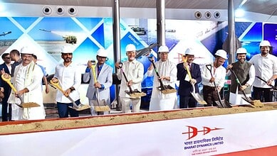 Construction workers at the Siasat Daily event in India, wearing white helmets and uniforms, participatin.