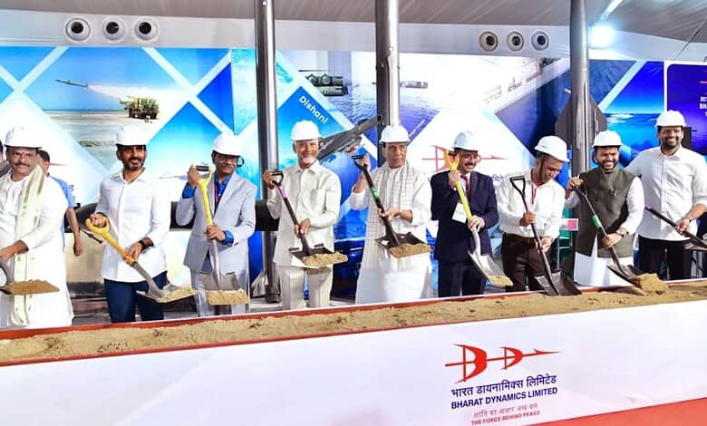 Construction workers at the Siasat Daily event in India, wearing white helmets and uniforms, participatin.