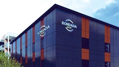 Bondada Group office building with modern black and orange facade, featuring the Bondada Group logo, unde.