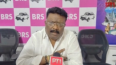 A man speaking into a microphone during a press conference at BRS event.