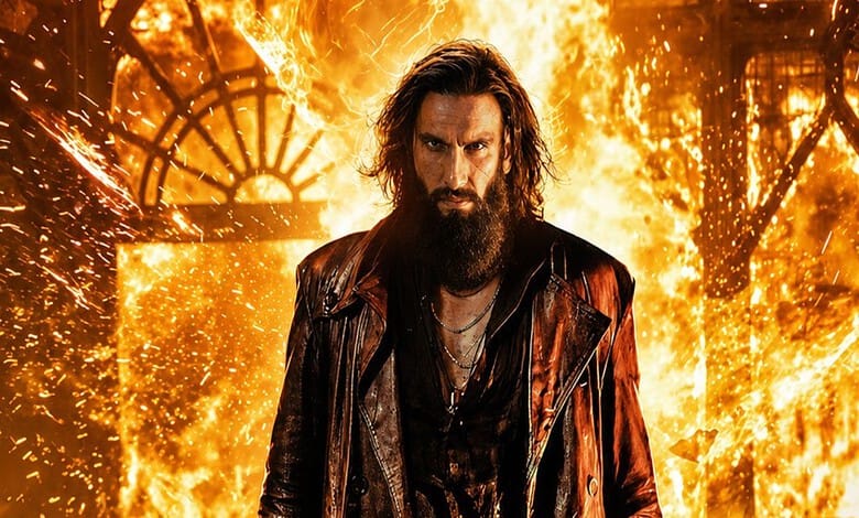 A man with long hair and a beard standing in front of a fiery background with sparks and flames.