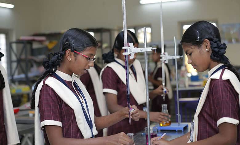 Students conducting science experiments in classroom with lab equipment.